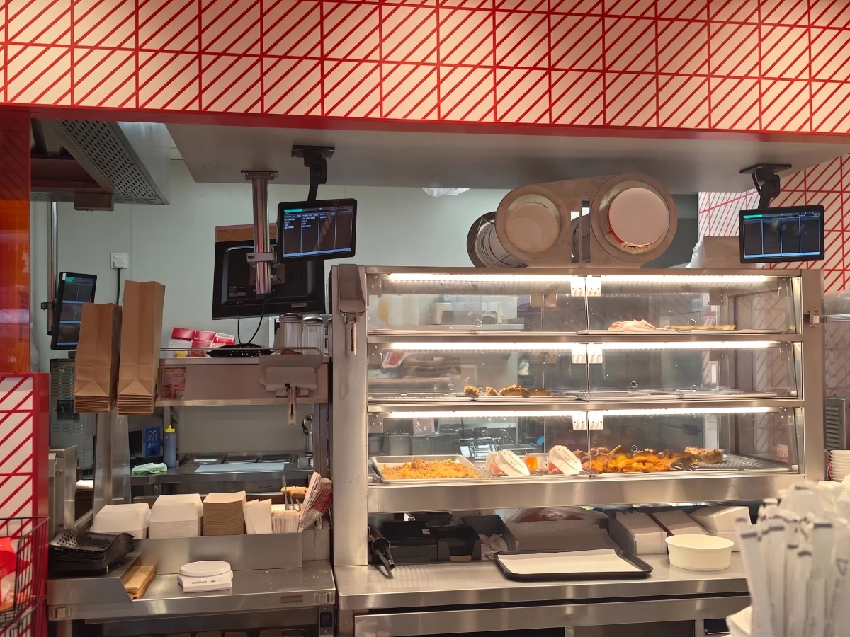 SUNTEK fast food QSR kitchen display system deployed above prep and packing stations showing order tracking screens and workflow in 2026